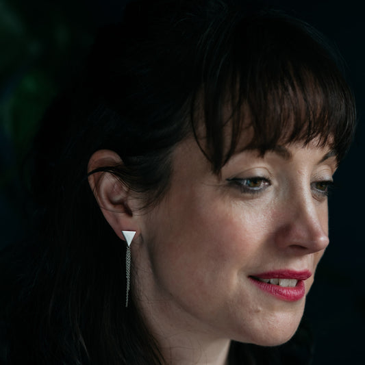 Silver triangle earrings with chain tassel on model