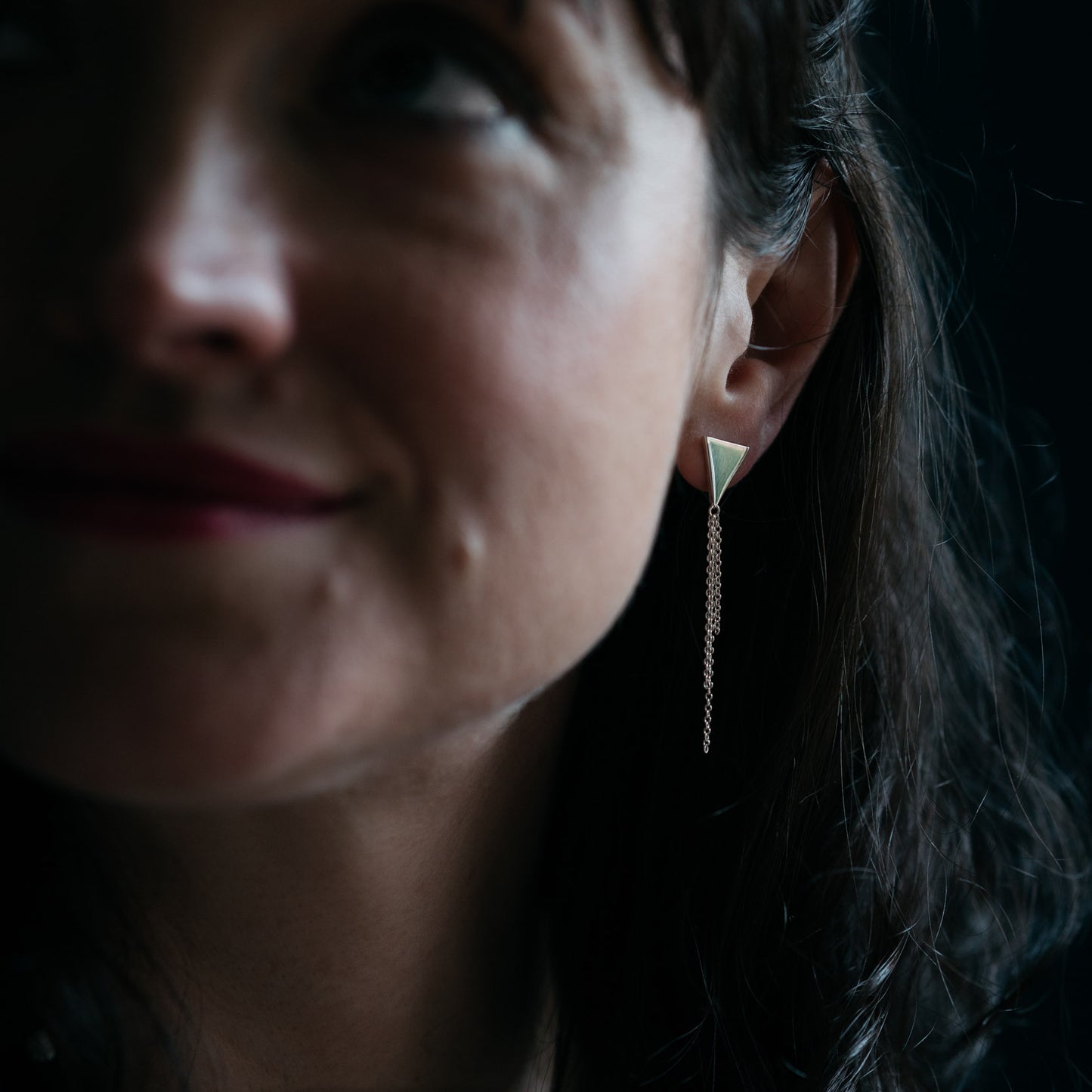 Silver triangle earrings with chain tassel on model