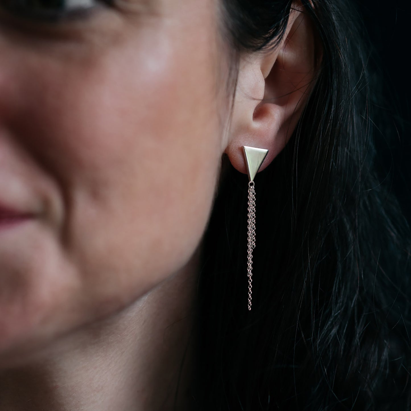 Silver triangle earrings with chain tassel on model