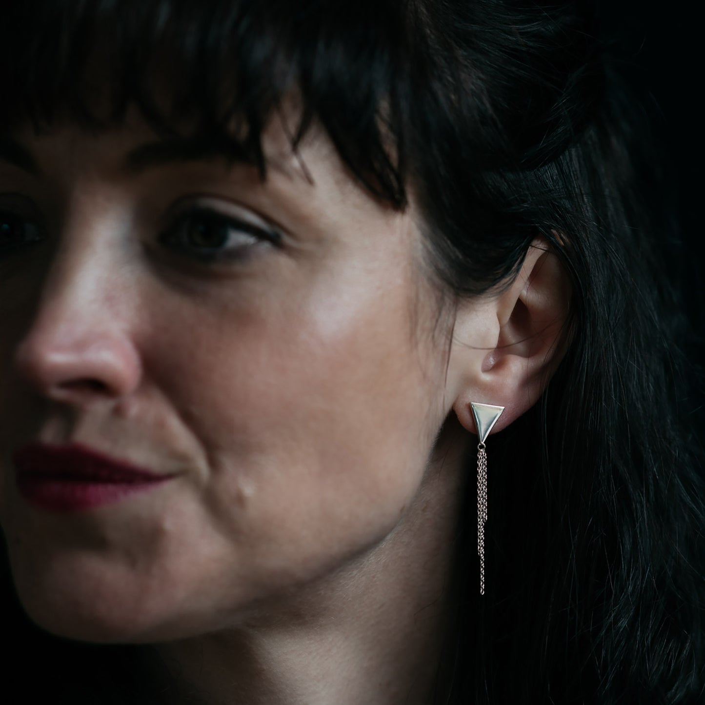 Silver triangle earrings with chain tassel on model