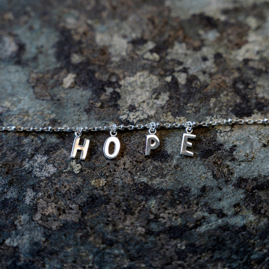 Silver hope bracelet on slate background