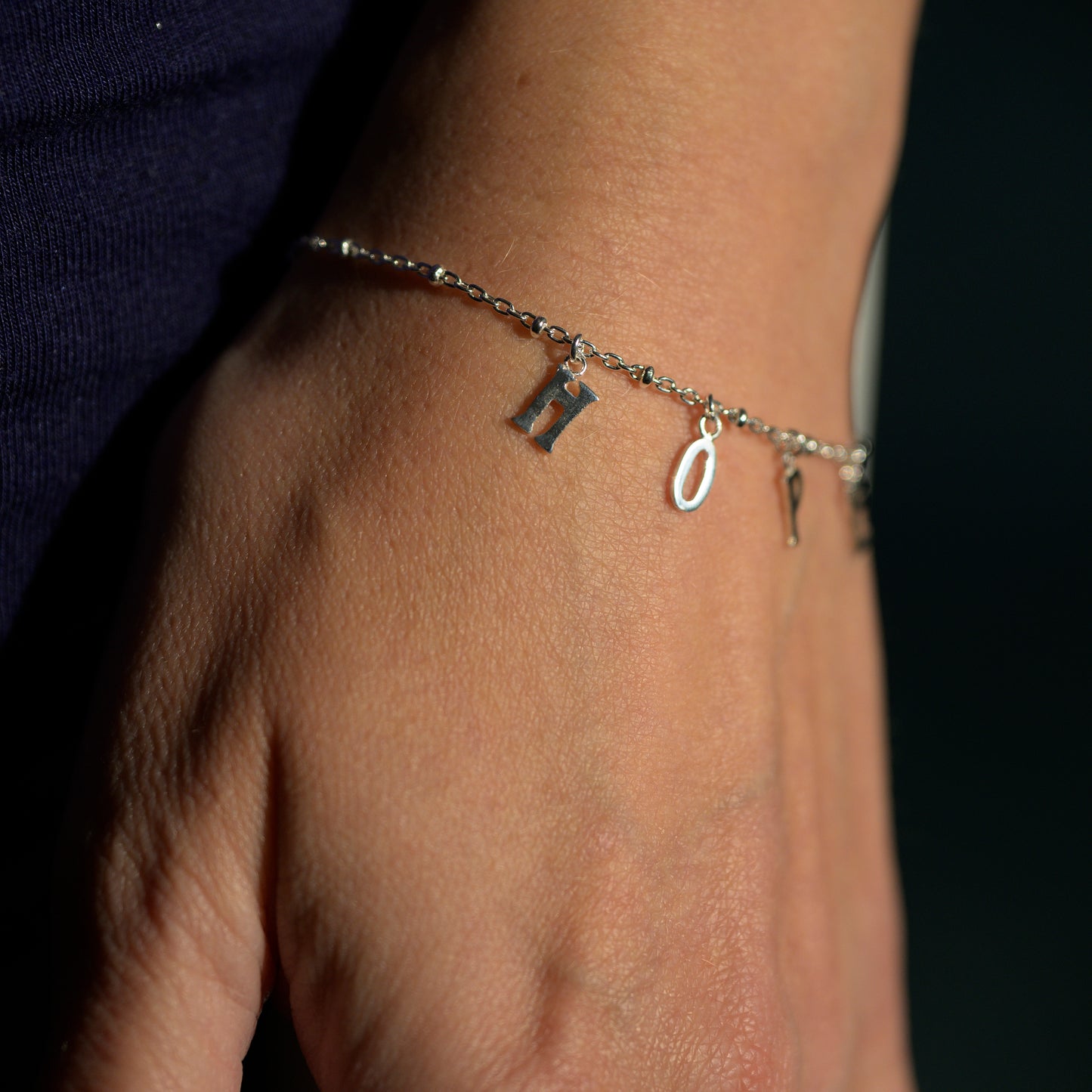 Close up of silver hope bracelet on model's wrist