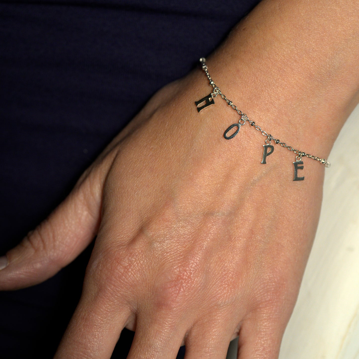 Silver hope bracelet on model's wrist