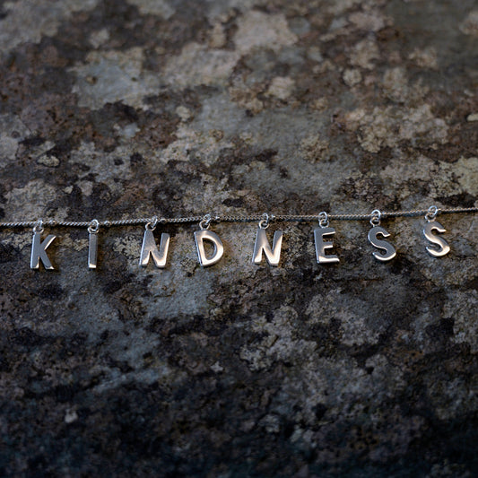 Silver Kindness necklace on slate background