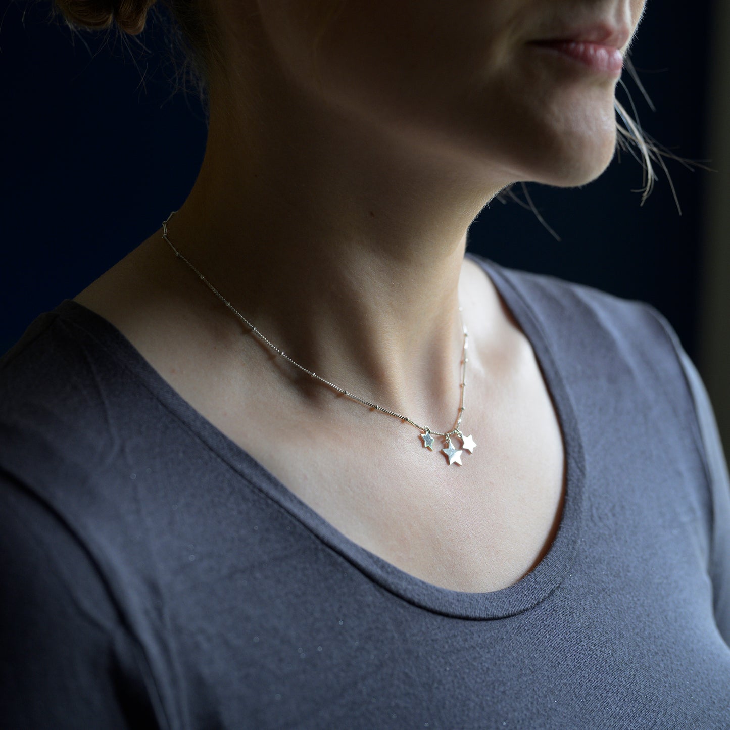 Silver three star necklace on model