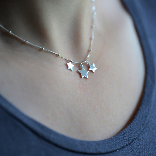 Silver three star necklace on model