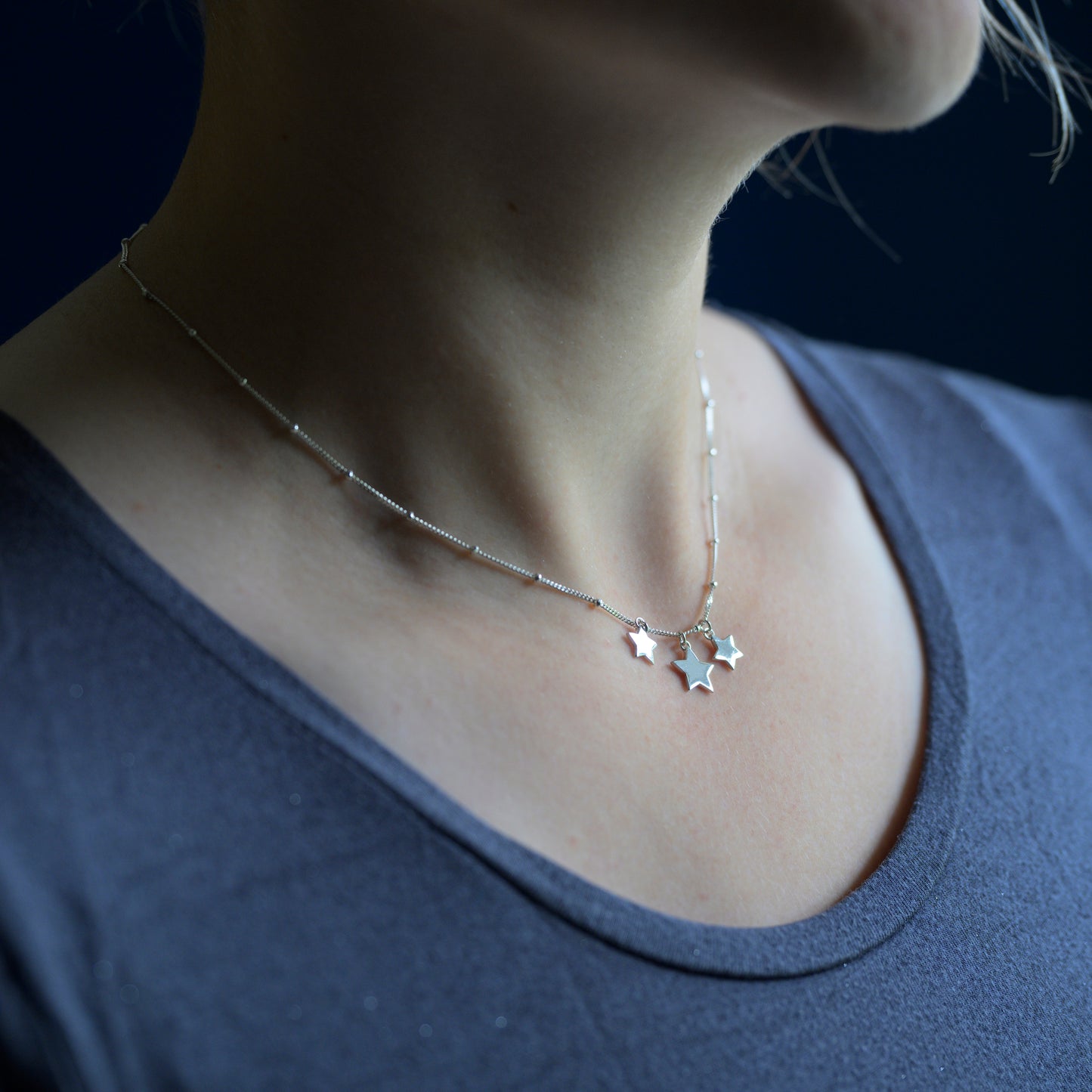 Silver three star necklace on model