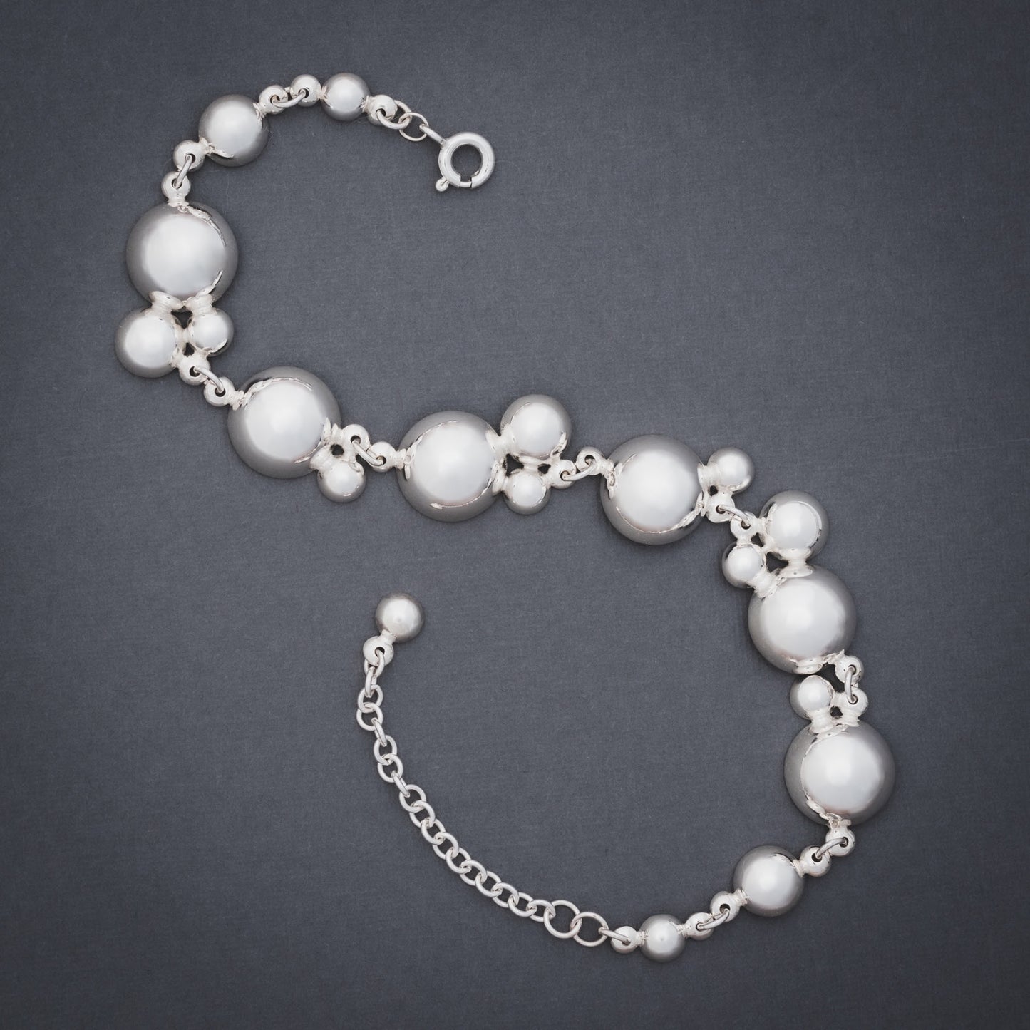 Product shot of silver bracelet with many domes