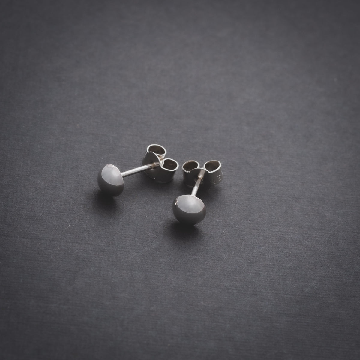 Product shot of silver domed stud earrings