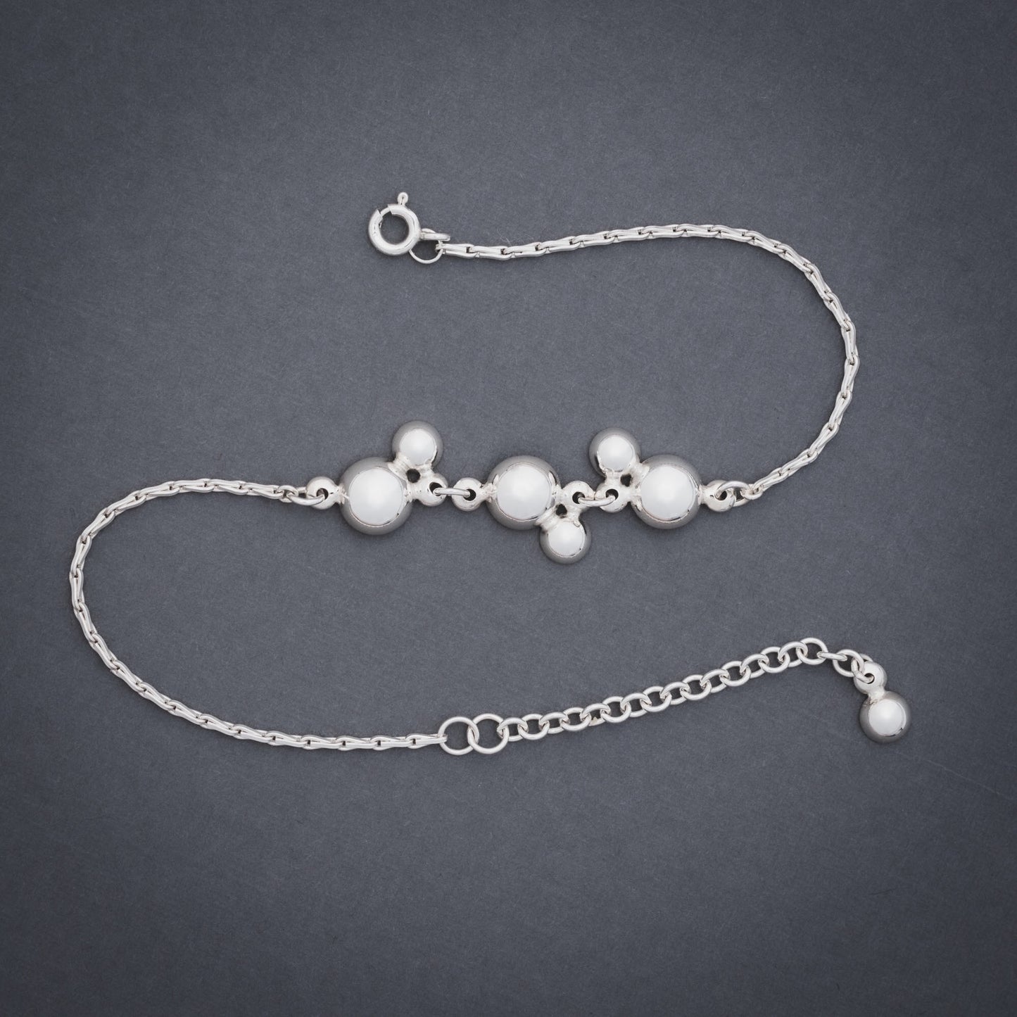 Product shot of silver bracelet with domes and chain