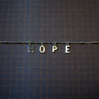 Silver hope bracelet on dark blue background