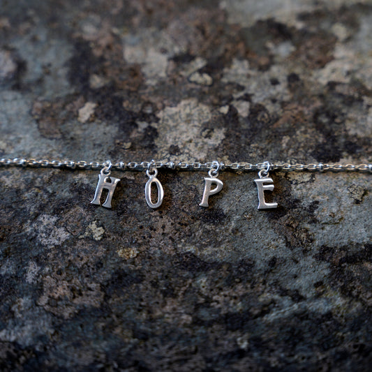 Silver hope bracelet on slate background