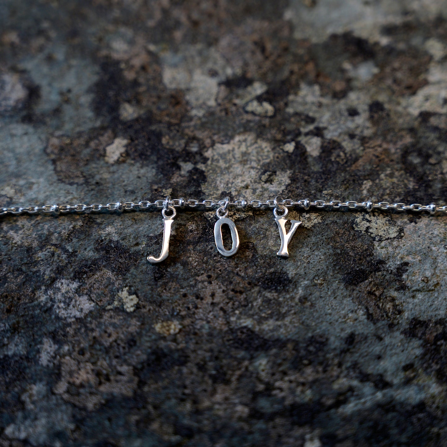 Silver joy bracelet on slate background