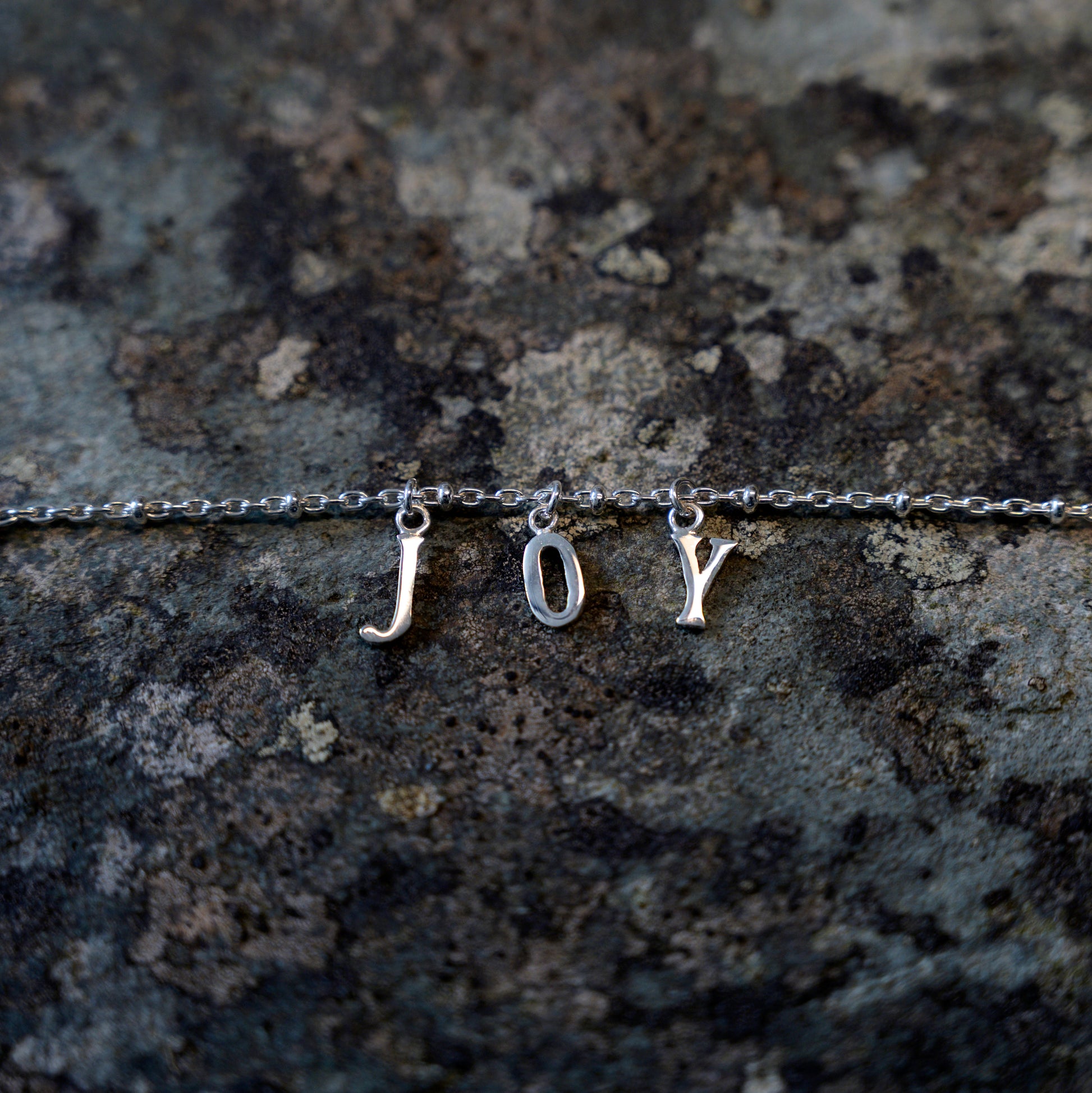 Silver joy bracelet on slate background