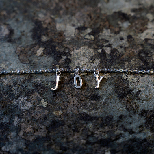 Silver joy bracelet on slate background