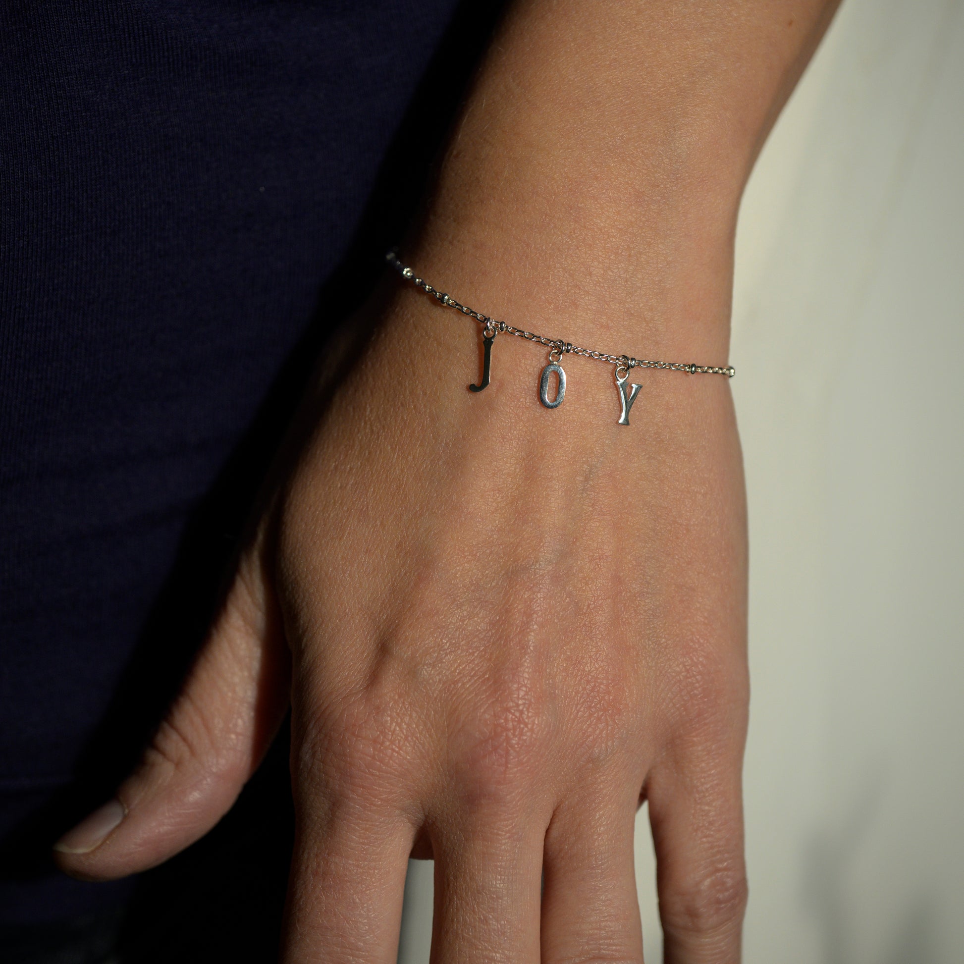 Silver joy bracelet on model's wrist