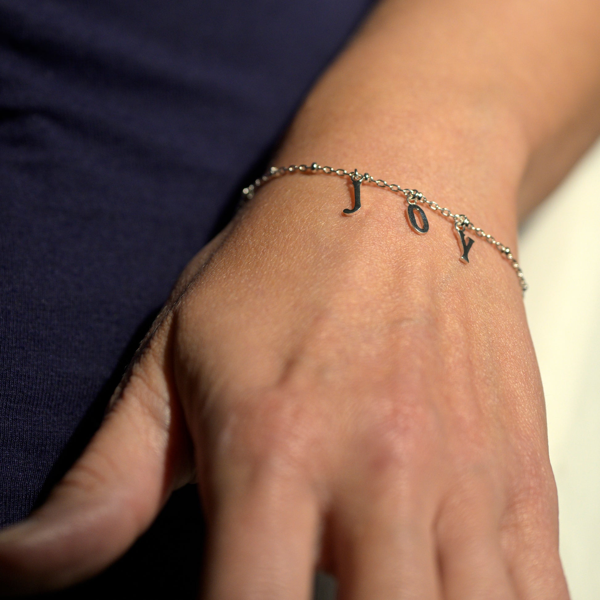 Silver joy bracelet on model's wrist