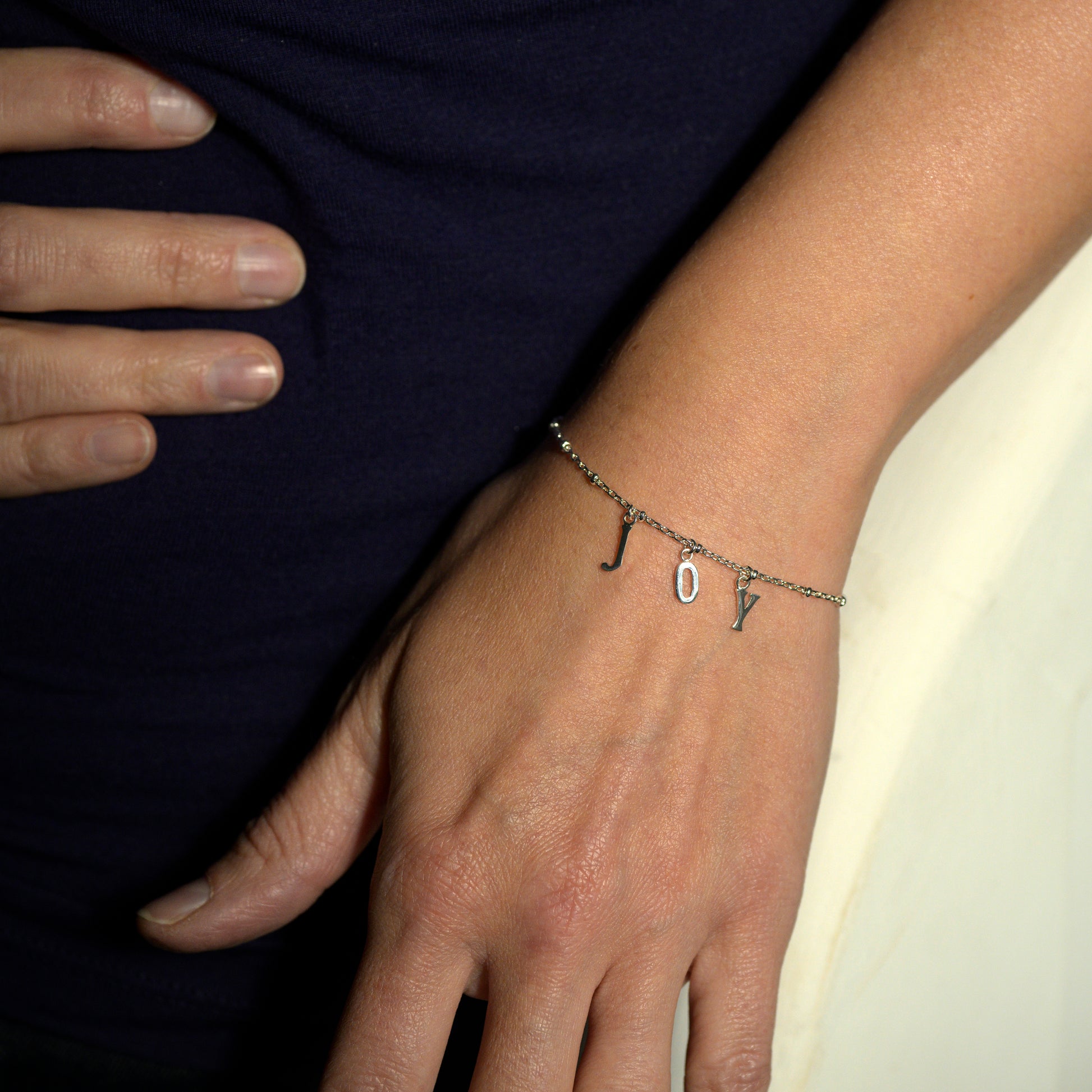 Silver joy bracelet on model's wrist