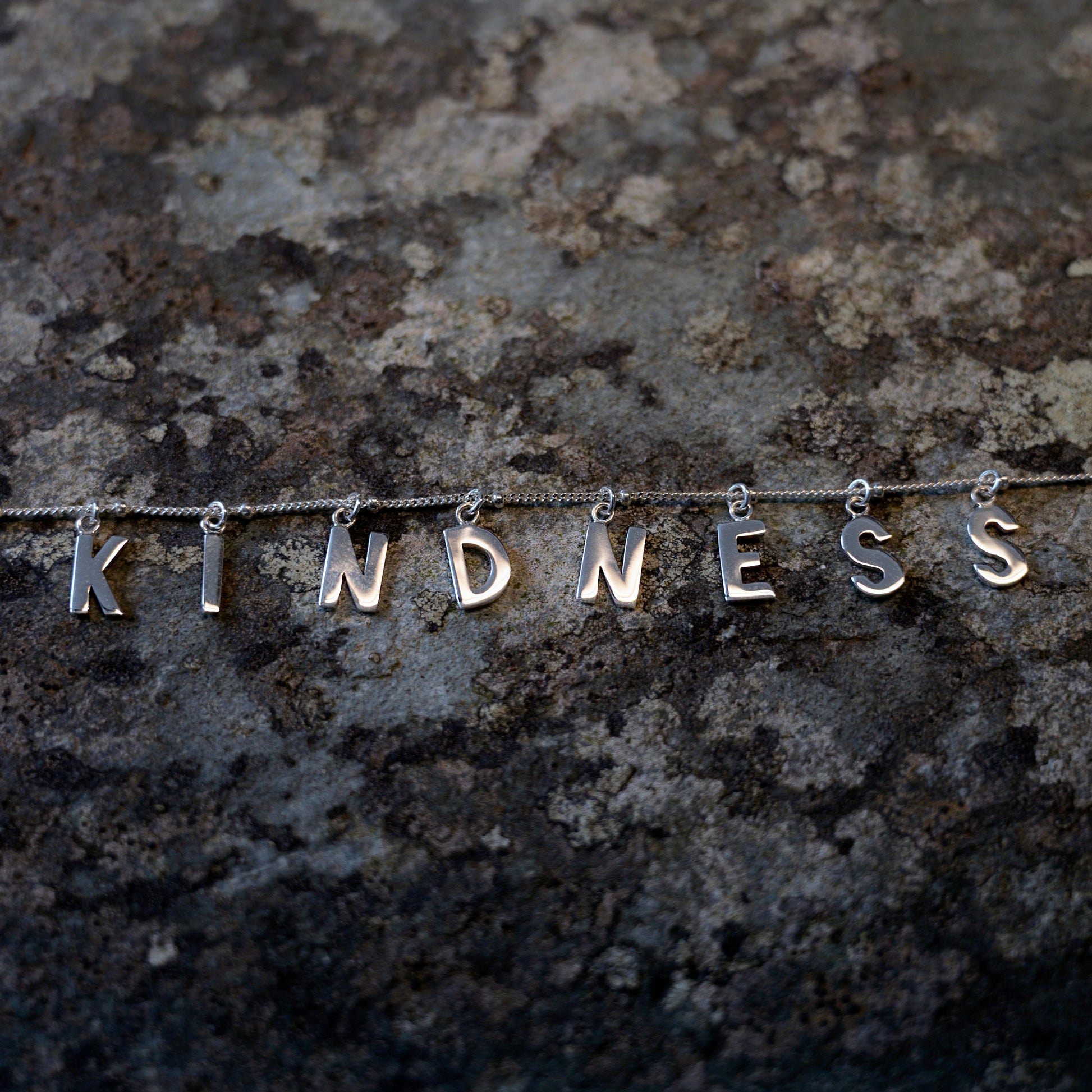 Silver Kindness necklace on slate background