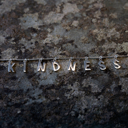 Silver Kindness necklace on slate background