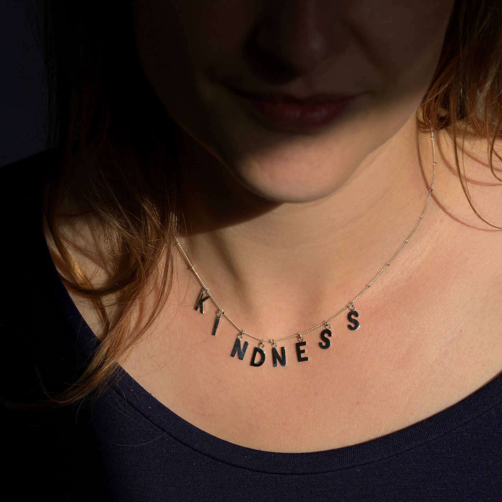 Silver Kindness necklace on model's neck