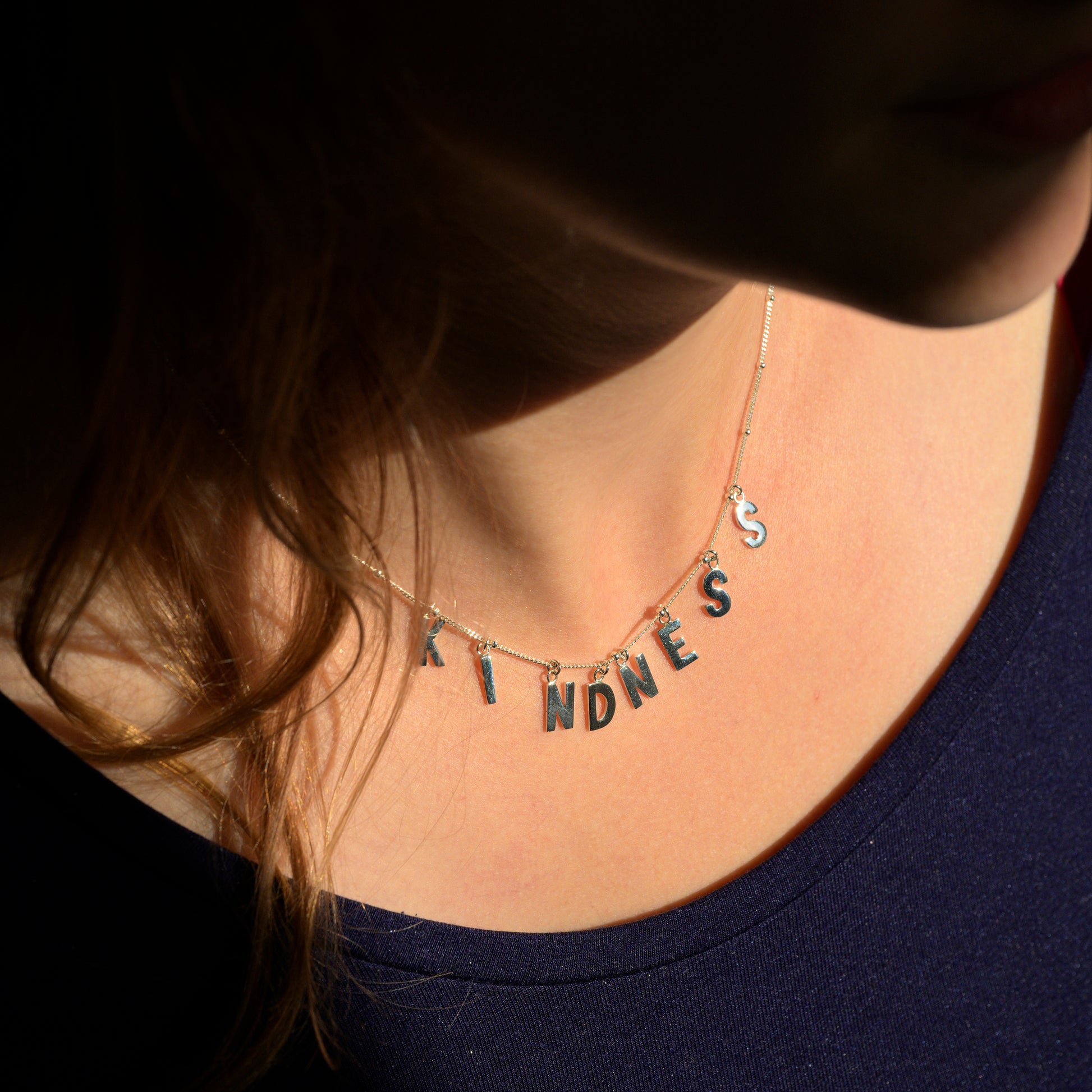 Silver Kindness necklace on model's neck