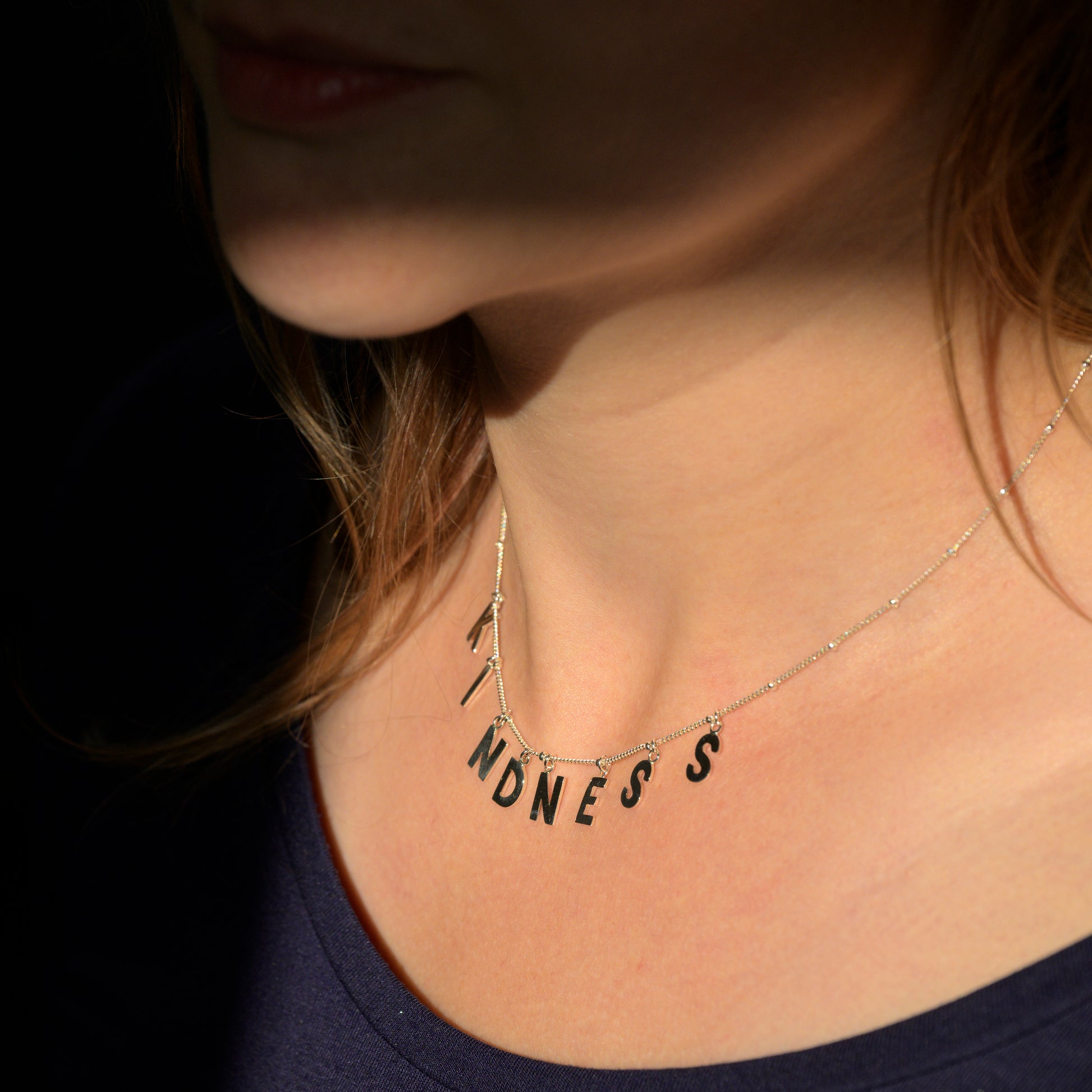 Silver Kindness necklace on model's neck