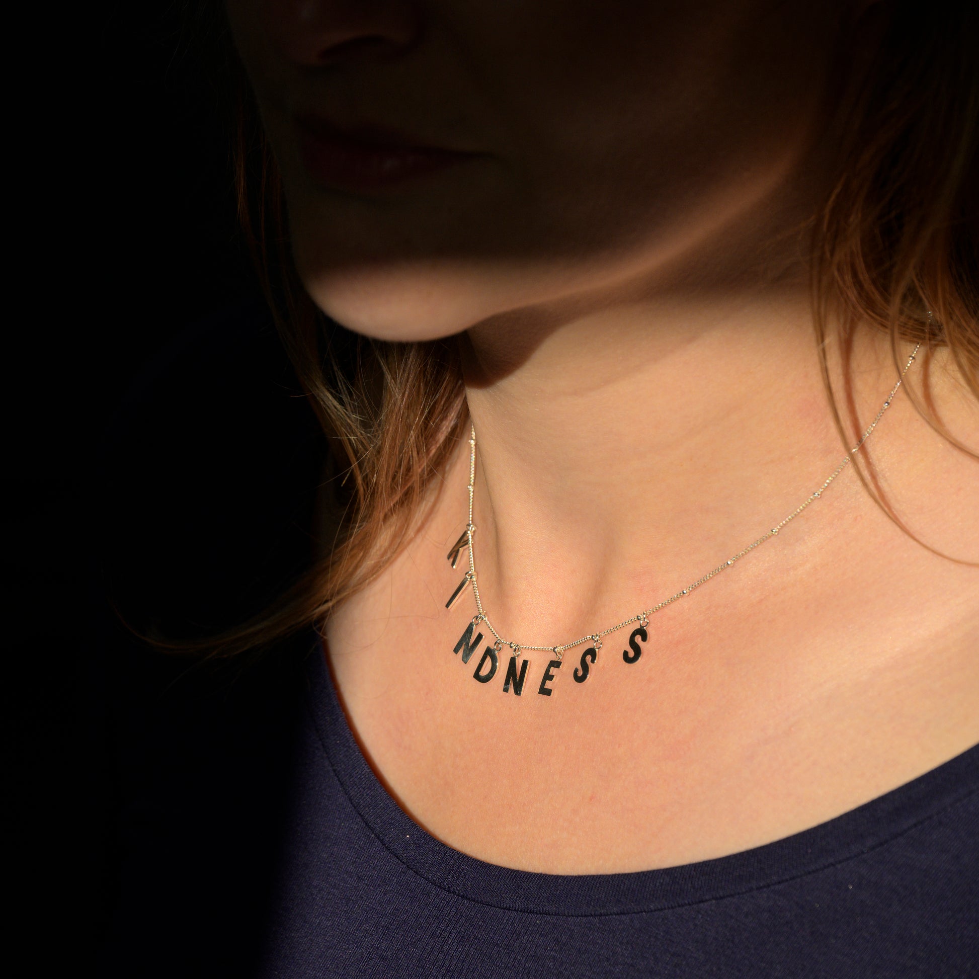 Silver Kindness necklace on model's neck