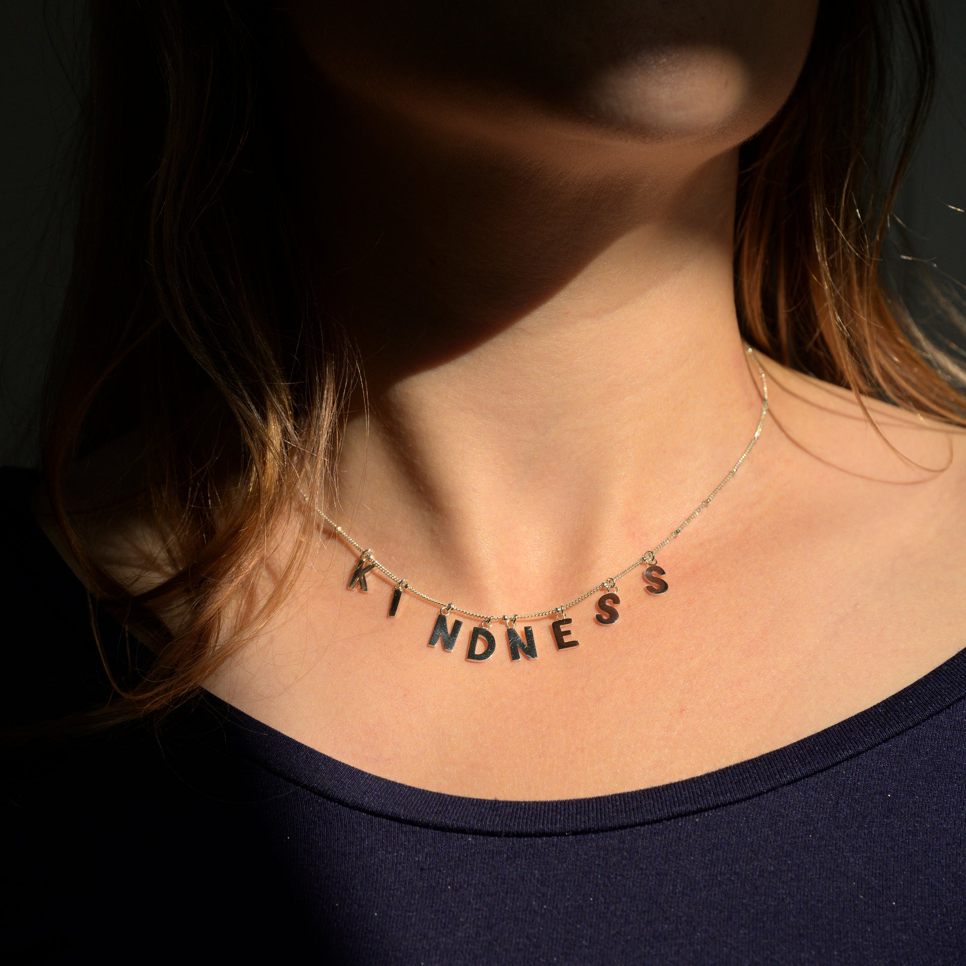 Silver Kindness necklace on model's neck