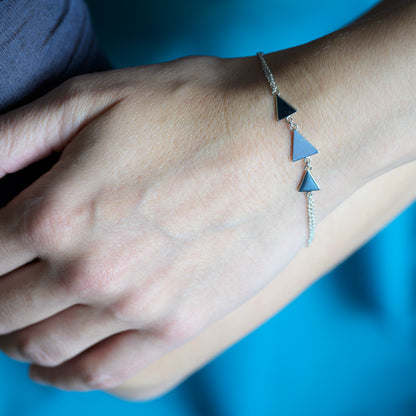 Silver bracelet with three triangles on model's wrist