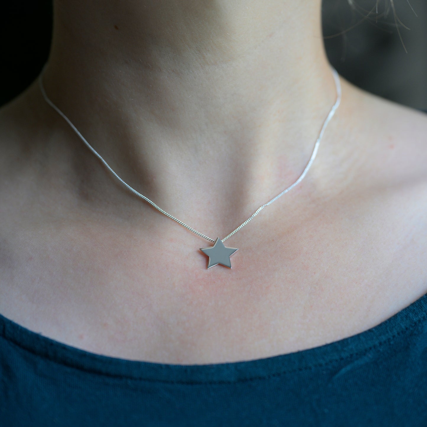 Silver star pendant on model