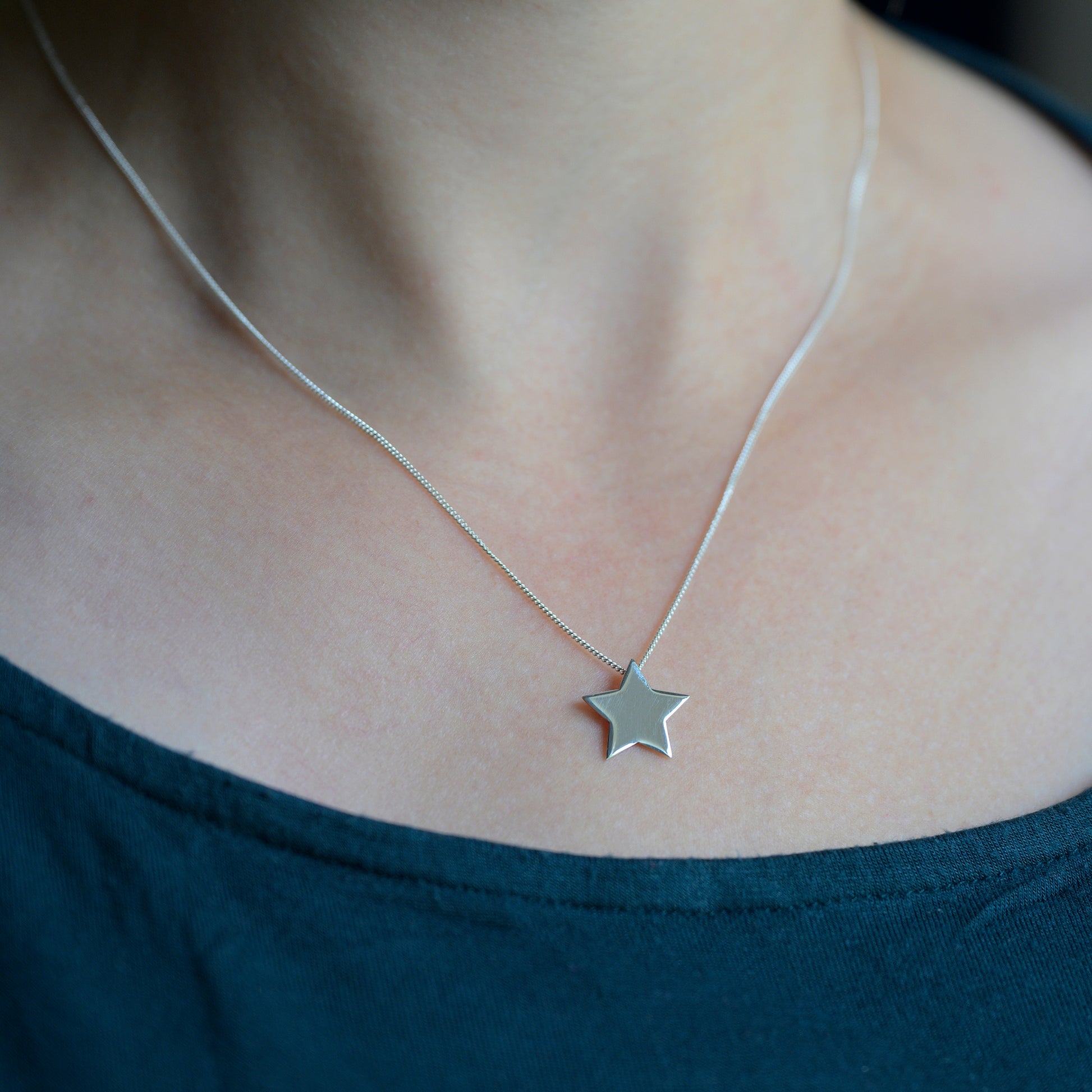 Silver star pendant on model