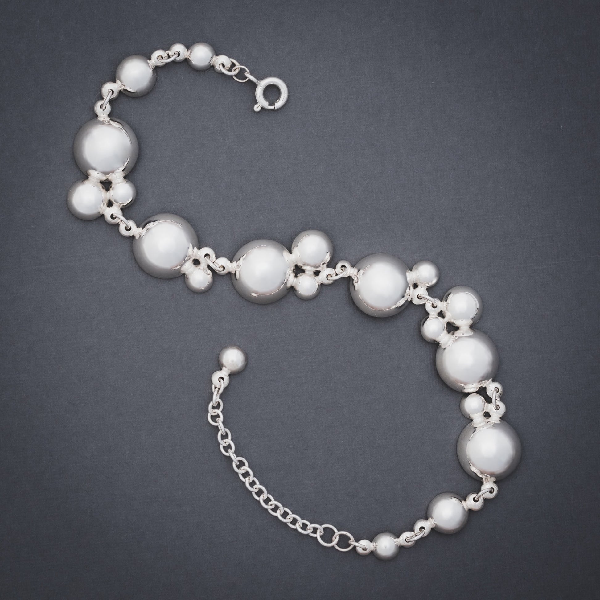 Product shot of silver bracelet with many domes