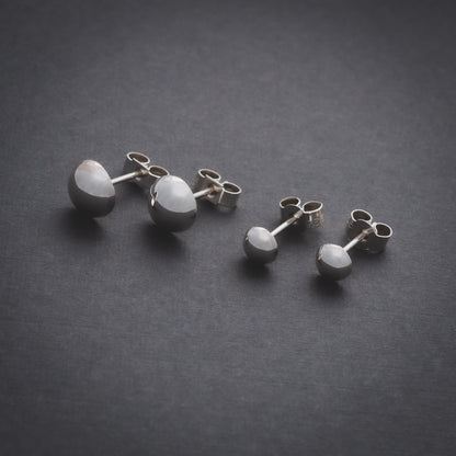 Product shot of two sizes of silver domed stud earrings
