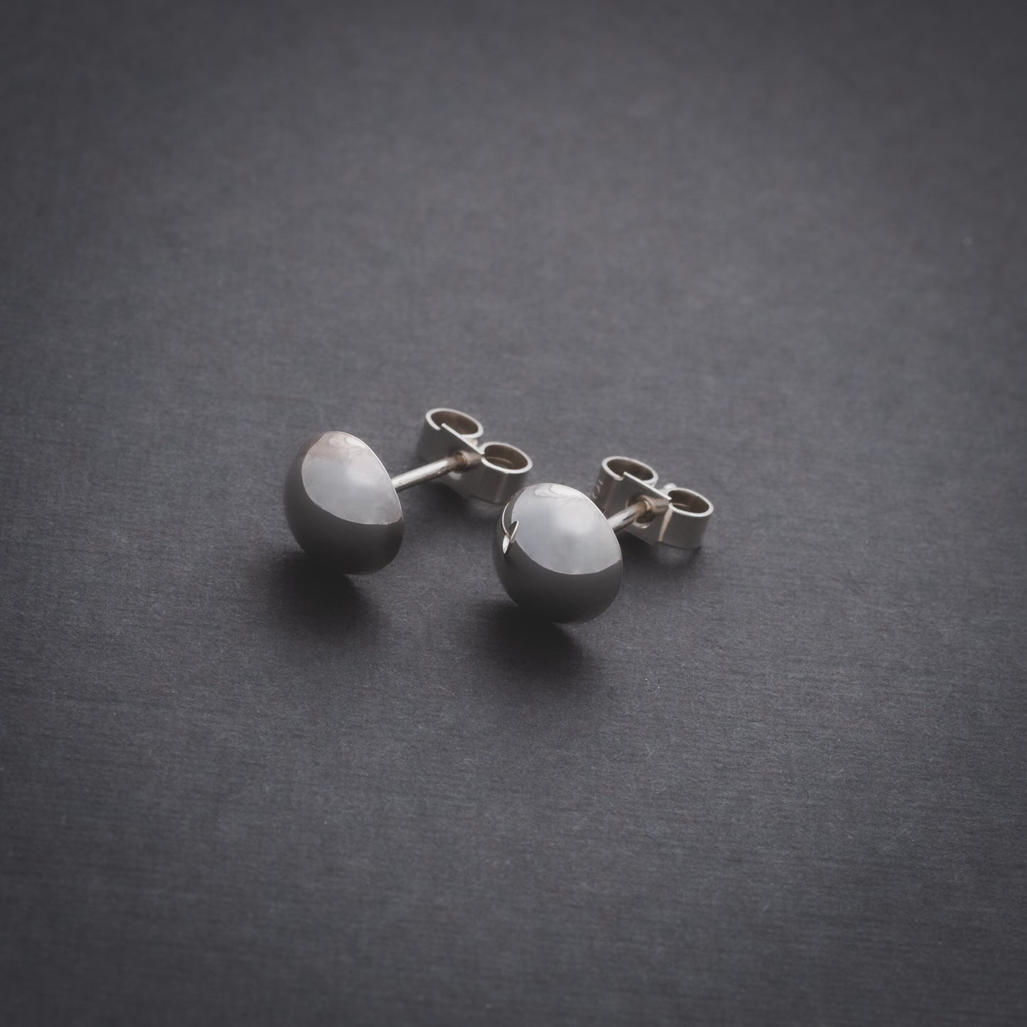 Product shot of silver domed stud earrings