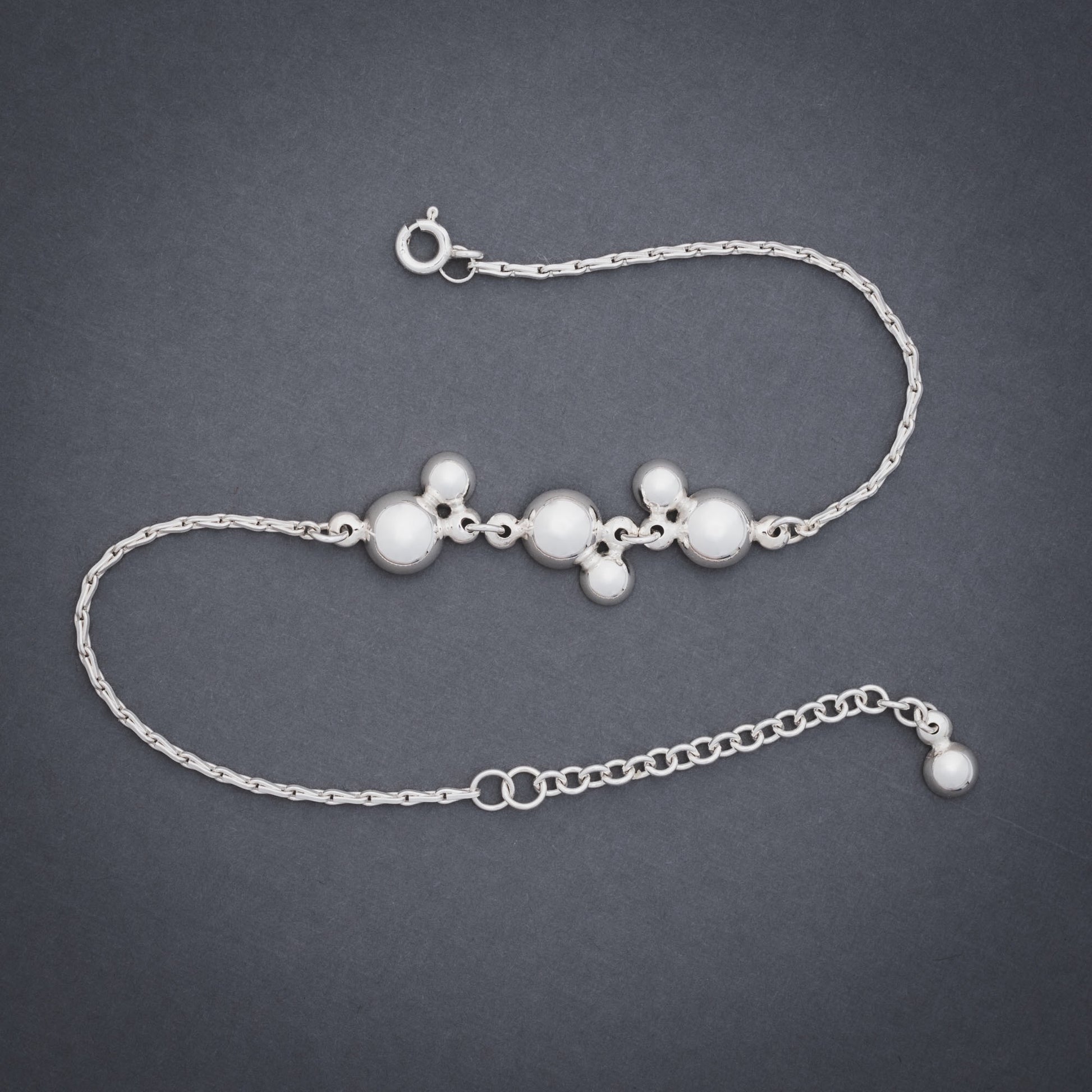 Product shot of silver bracelet with domes and chain